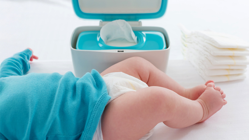 bambino su fasciatoio con contenitore salviette umidificate